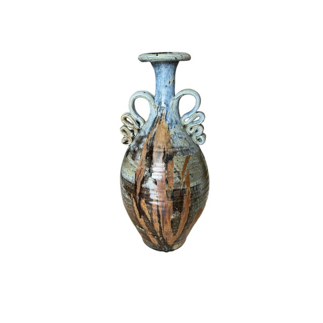 This stunning vase is a true work of art. With its triple handled design and hand painted finish, it is a unique piece...