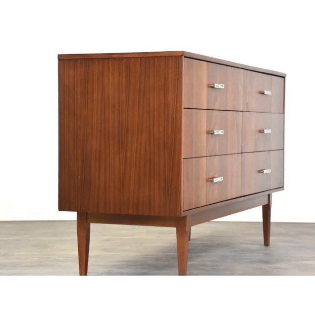 A mid century modern walnut six drawer dresser with polished chrome and green tile drawer pulls made by Kroehler...