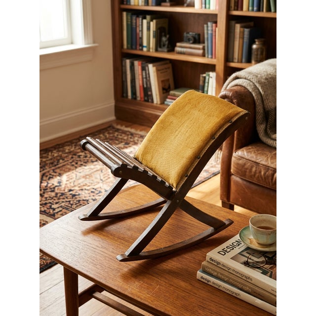 A compact and characterful kneeling stool with warm mustard upholstery and a sculptural wooden frame. Its simple lines and...