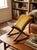 A compact and characterful kneeling stool with warm mustard upholstery and a sculptural wooden frame. Its simple lines and...
