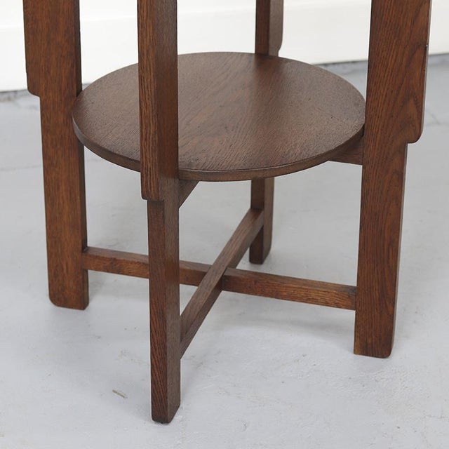 A distinctive Art Deco side table from the 1930s, crafted from solid oak. The table features a graceful base and an...