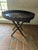 Round dark wood tray table with a deep fluted gallery and scalloped rim, set on a hand carved folding X stand with leaf...