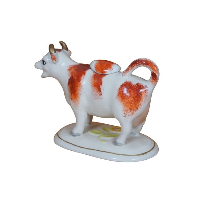 Antique 19th century Staffordshire porcelain cream pitcher in the shape of a red and white cow on an oval base, molded and...
