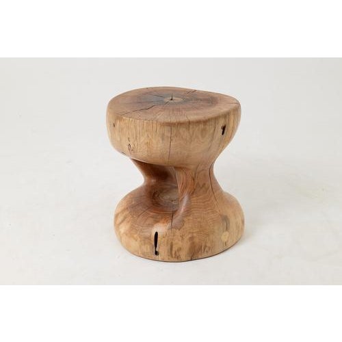 Carved from a single solid log, this side table has a quiet sculptural authority that is hard to place and easy to...