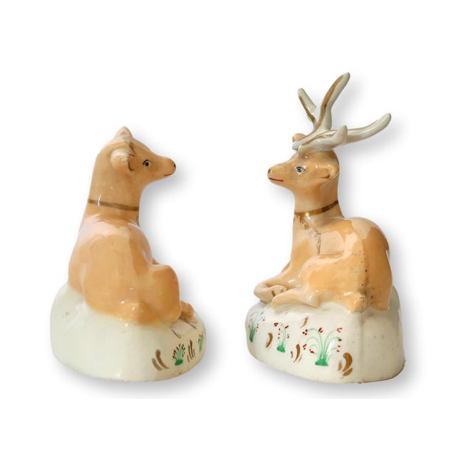This charming pair of early 19th-century porcelain figures features a delicately hand-painted doe and deer resting on...