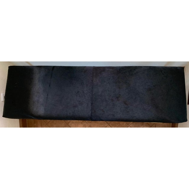 Cowhide upholstered bench mounted on tubular brass modern base