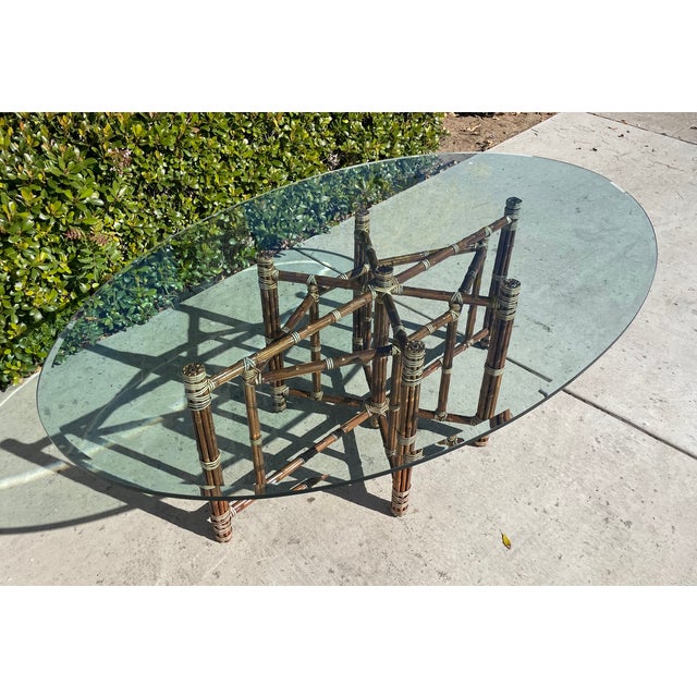 Large & graceful oval shaped dining table Attributed to McGuire of San Francisco. Crafted from bundled bamboo over an...