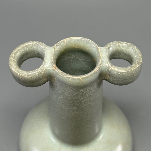 Classic Chinese official‑style celadon arrow vase, featuring distinctive tubular side handles, tall slender neck and...