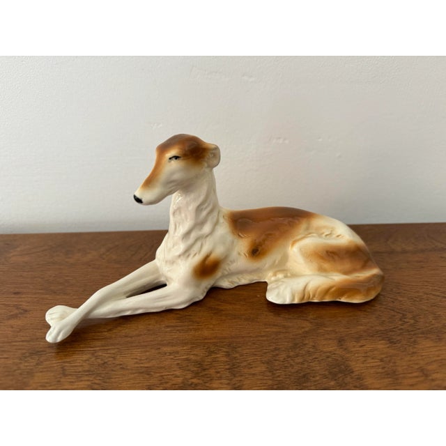 Stunning antique German porcelain reclining wolfhound borzoi dog. An elegant sculpture to accent any style decor....