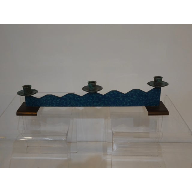 A Memphis styled candle stick center piece with blue toned copper enameled jagged step up design with three patina candle...