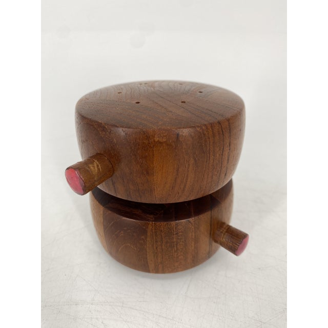 A salt and pepper mill * Combined salt shaker (top) and pepper mill (bottom) * Made of solid teak * High-quality Peugeot...