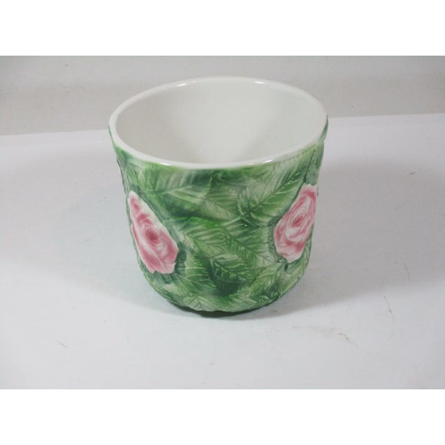 A hand painted ceramic cachepot, made in Italy. It has all over raised patterns of green leaves and pink roses. A...