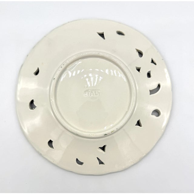 This beautiful 8" reticulated plate is one of three in our collection, each with a unique floral majolica painting with...