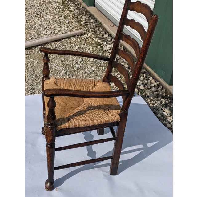 Vintage ladder back oak arm chair is in good condition. This chair has few imperfections. It is sturdy and would be a...