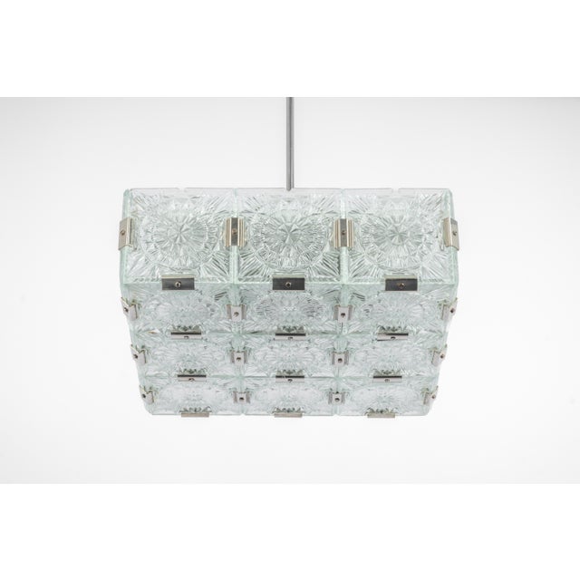 Stunning mid-century glass chandelier made in germany, 1970s. A square form gathers structured glasses, beautifully...