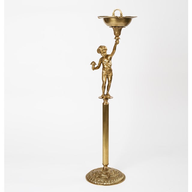 A vintage free standing heavy brass ashtray with a figurine of a boy holding a ash tray. Spain circa1960s. Has cut outs...