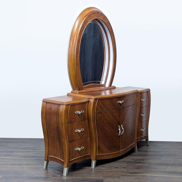 This Michael Amini dresser features a stylish wood finish, an attached large oval mirror, and plenty of storage with six...