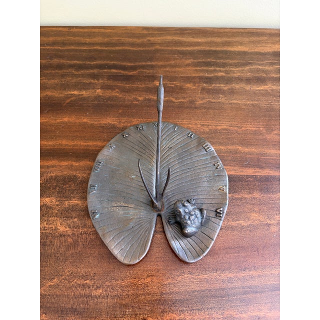 A stunning vintage iron garden sundial featuring a charming frog on a lily pad USA, Late 20th Century Measures: 7.75"W x...