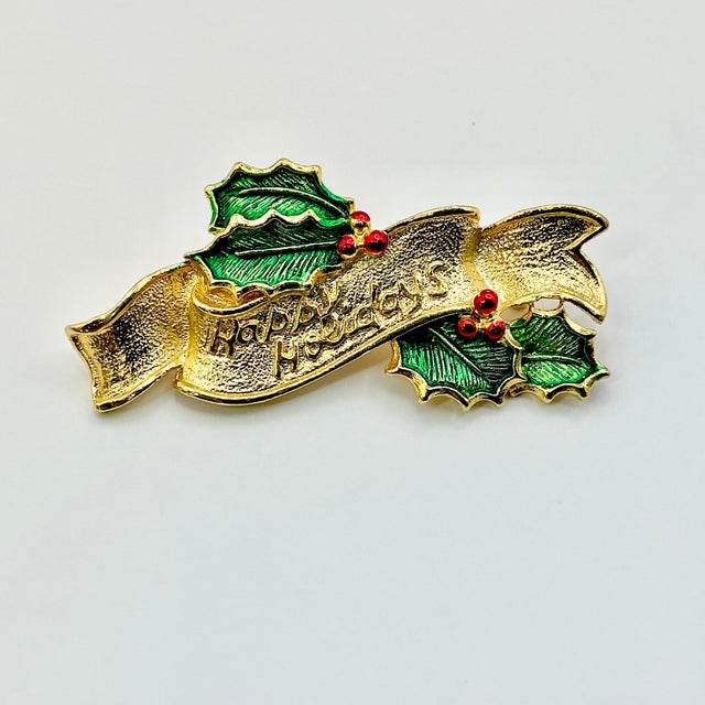 A lovely Christmas Brooch from Gerry’s Creatives from the 1950s. It features a gold-tone ribbon that it engraved with...