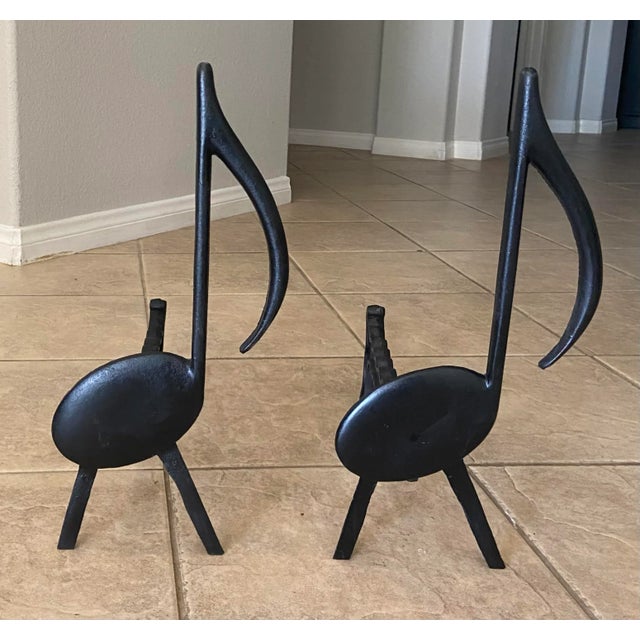 Pair of Mid-Century black cast iron music note motif fireplace andirons by Tennessee Chrome Plate of Nashville.