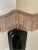 A lovely art deco black ceramic lamp with gorgeous silk shade with fringe trim. Shade features a tone on tone floral pattern.