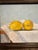 Oil painting by Texas artist, Jill Pavlas, of lemons on a tablecloth. Framed in a custom frame.