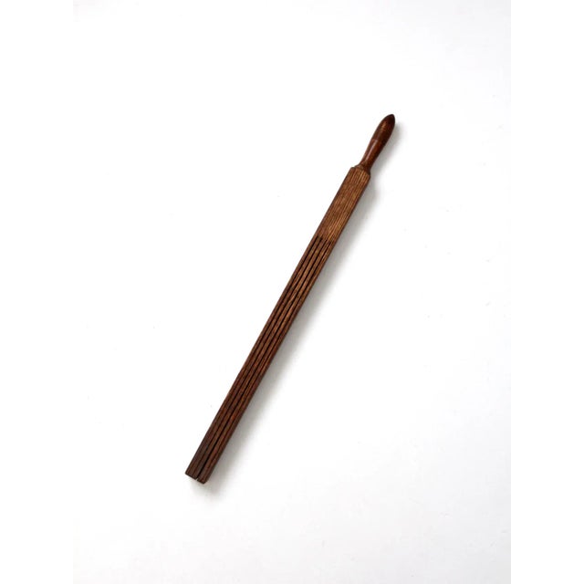 Antique primitive tool featuring a long wooden bar with slatted cuts and a turned wood handle. Its simple, utilitarian...