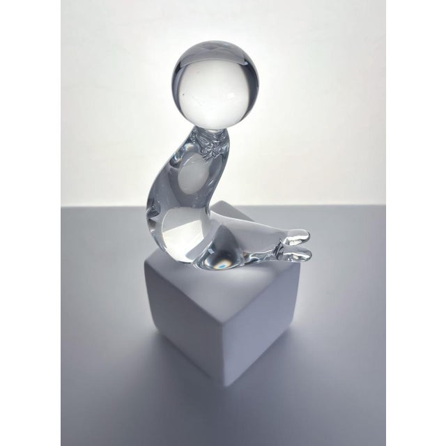 A modernist-style sea lion paperweight, crafted in the 1960s by Swedish glassmaker Folke Walving. Made from clear,...