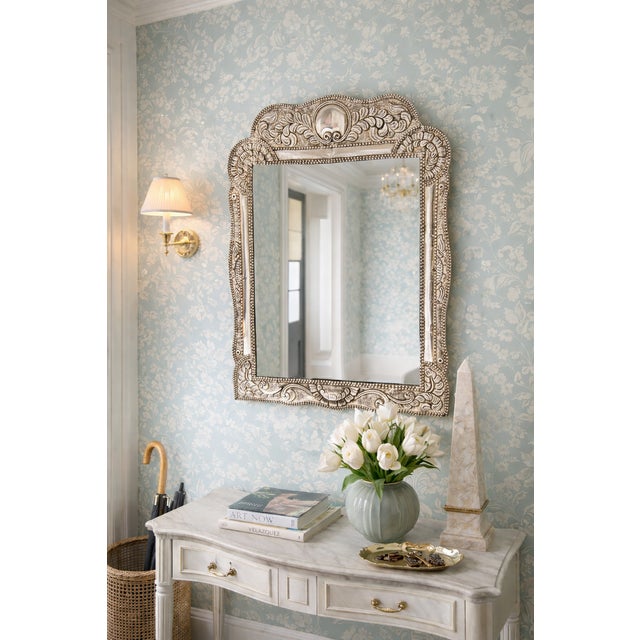 A large 1920s Peruvian 925 sterling silver repoussé wall mirror with ornate hand-embossed floral and scrollwork detail....