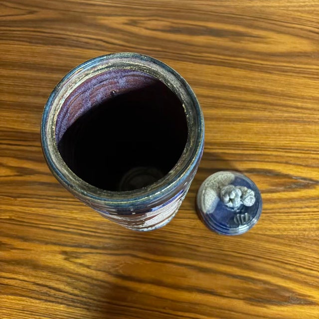 Tall vintage studio pottery lidded vessel with a striking, layered glaze in deep indigo, oxblood, rust, and cream. Bands...