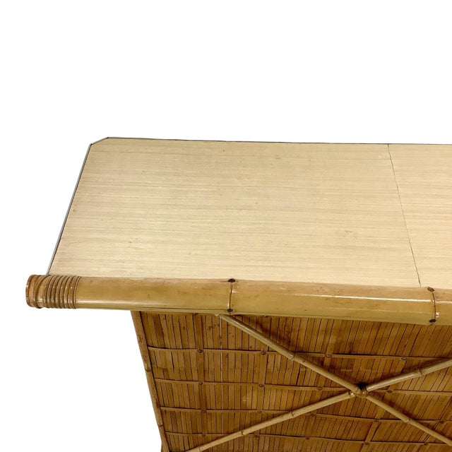 This vintage freestanding bar brings together substantial bamboo construction, woven rattan detailing, and a wonderfully...