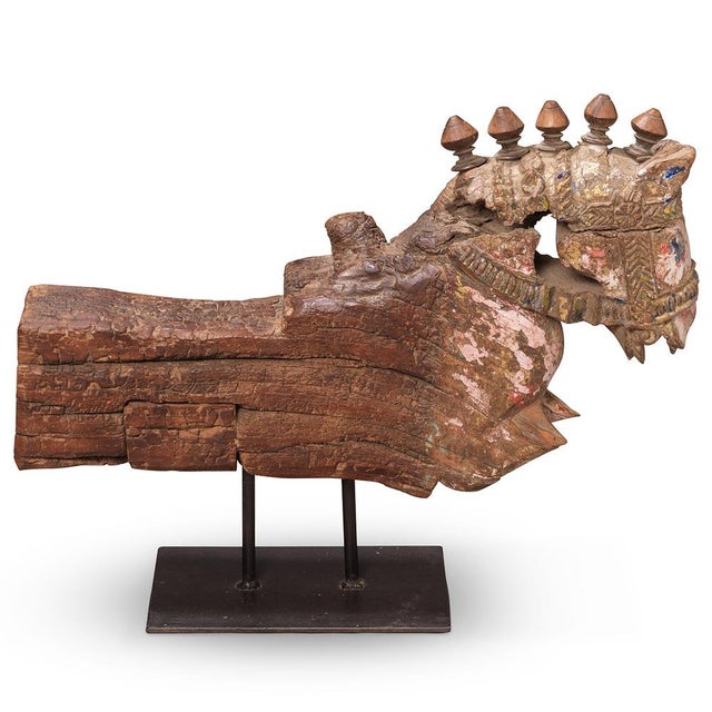 A striking hand-carved wooden horse from Gujarat, mounted on an iron stand. The piece showcases bold, stylised carving...