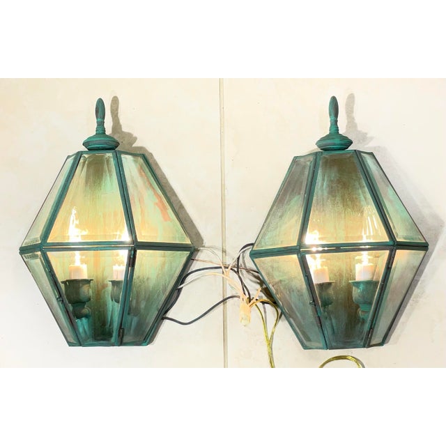 exquisite pair of solid brass wall lanterns. Featuring a striking verdigris patina finish, these lanterns capture the...