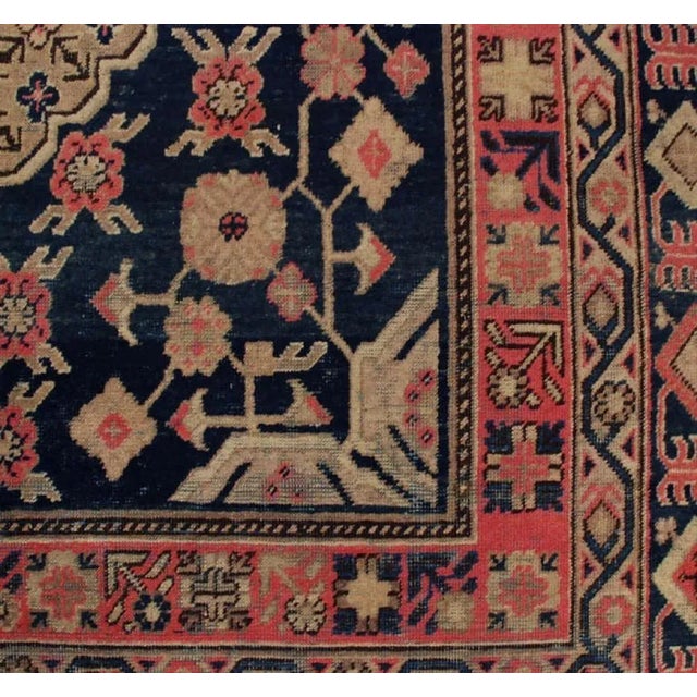 An antique Central Asian Khotan rug with all-over floral diamond pattern amidst a field of flowers and vines, surrounded...