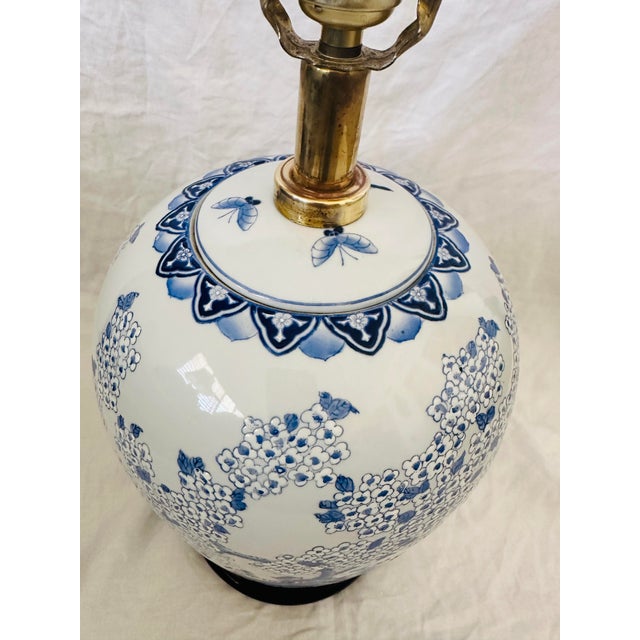 Vintage Blue & White Chinoiserie Table Lamp with shade. Has a wooden base, floral design throughout the lamp. Perfect for...