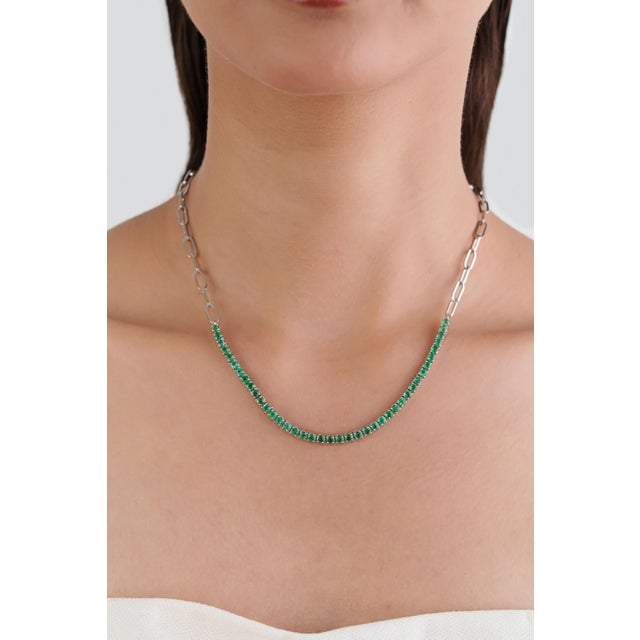 This modern tennis necklace features 3.85 carats of natural round emeralds, set in 18K white gold. Each emerald measures...