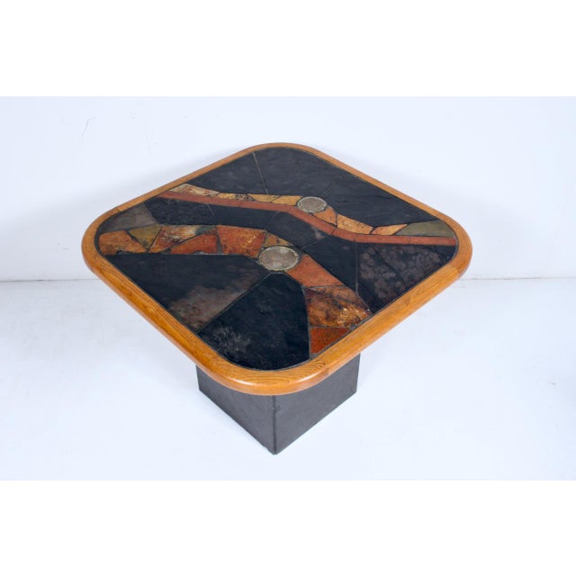 V. Ramburrem attributed inlaid African slate, stone, wood and brass art side table. Featuring a rounded square form with...