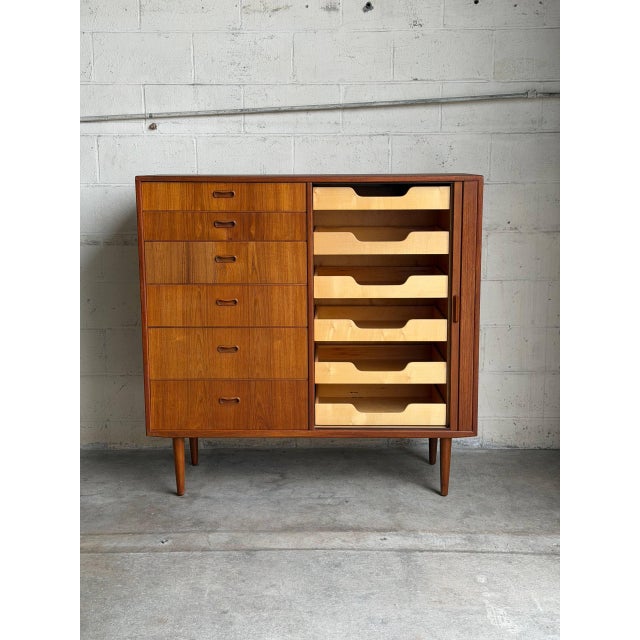 This exceptional highboy dresser features an asymmetrical front configuration with a vertical stack of six deep storage...