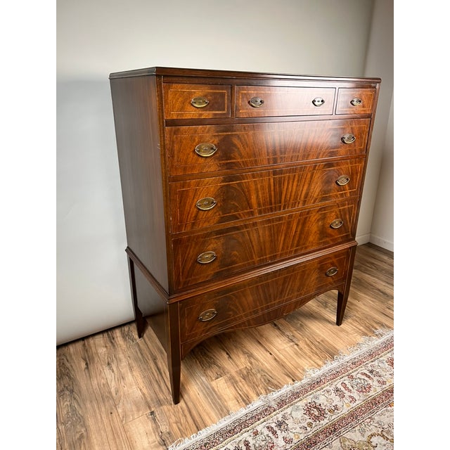 A beautiful interpretation of classic American Federal design, this vintage chest on stand was produced by the highly...
