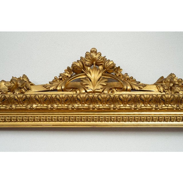 An antique Roman frame in gilded, carved wood dating from the early 19th century. The frame features a complex molded...