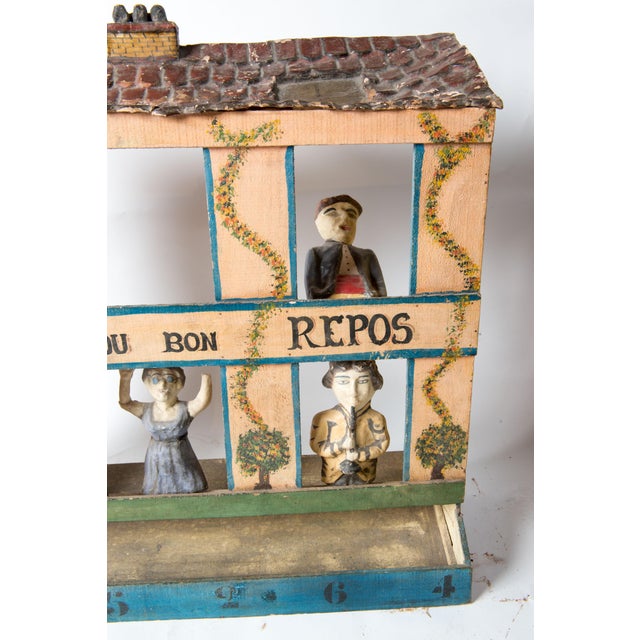 An old French game, hand painted wood and papier mache with five figure in the windows and a detailed papier mache "tiled"...