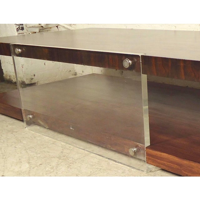 Stunning and substantial vintage modernist two-tiered coffee table. The rosewood veneer features a truly one-of-a-kind...