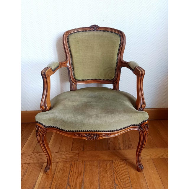 Louis XV style cabriolet armchair upholstered in sage green velvet with a floral design on the upper part of the back....