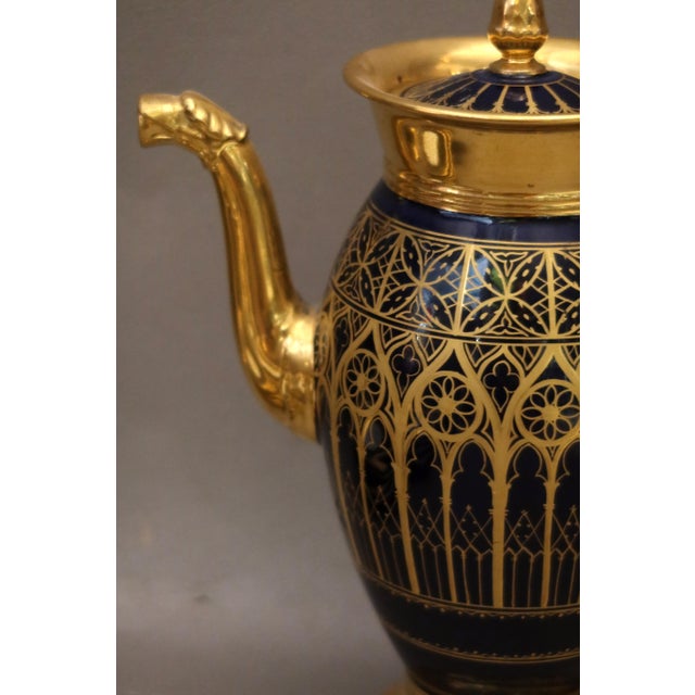 A Paris porcelain coffee pot with a cobalt blue ground and fine gold gilding, decorated with Gothic arches in the...