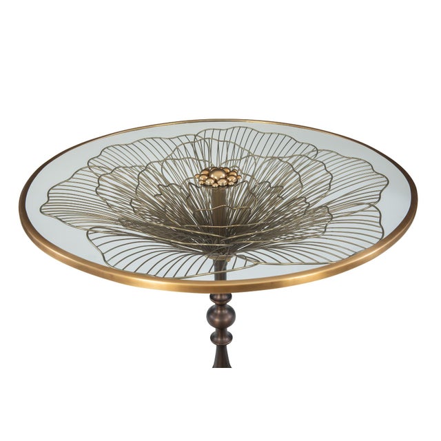 Brass center table featuring a lily flower sculptural base. Contrasting oil rubbed bronze base with a brushed brass top....