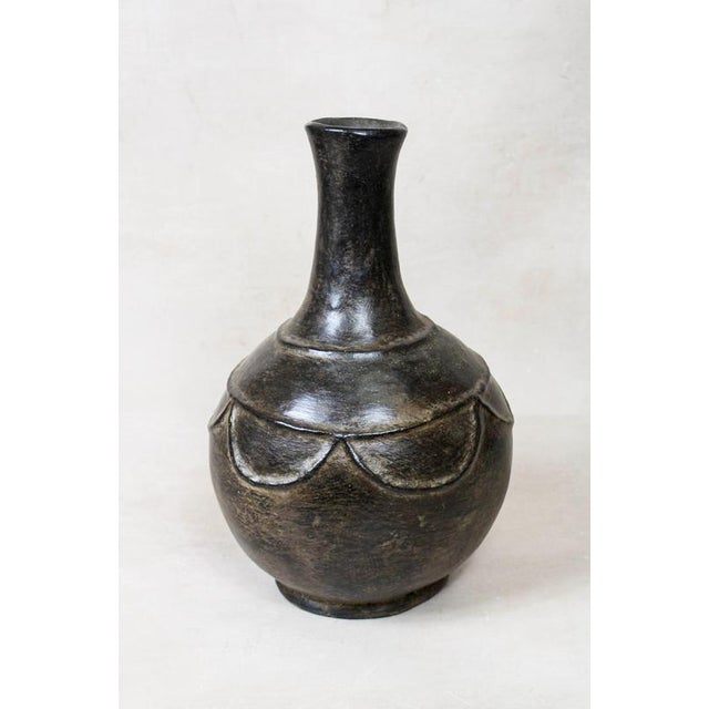 This Mangbetu Vase is a masterful blend of functional pottery and soulful sculpture, hand-crafted by the Mangbetu people...