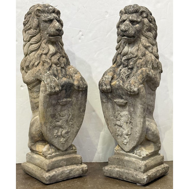 A pair of fine armorial lion garden statues from England - each lion elegantly poised on a stepped plinth base, exuding a...