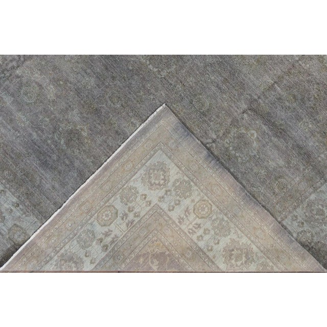 A modern grey overdyed rug from Pakistan featuring a subtle underlying all-over design. This rug is hand-knotted using...