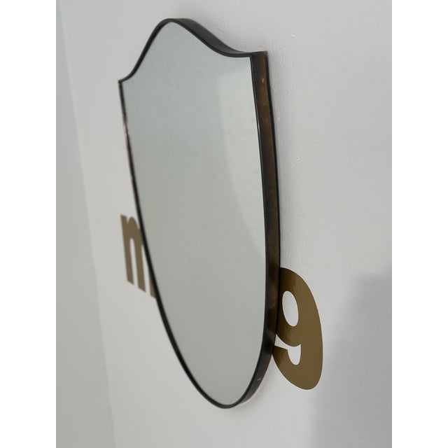 The Vintage Italian Brass Shield Mirror from the 1970s is a sleek and striking piece that epitomizes the bold design...