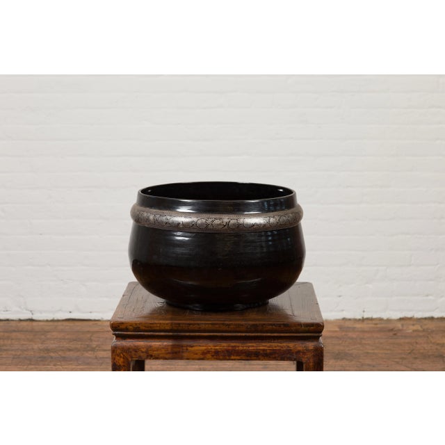 A Burmese vintage black lacquer bowl from the mid 20th century, with silver highlights. Created in Burma during the...